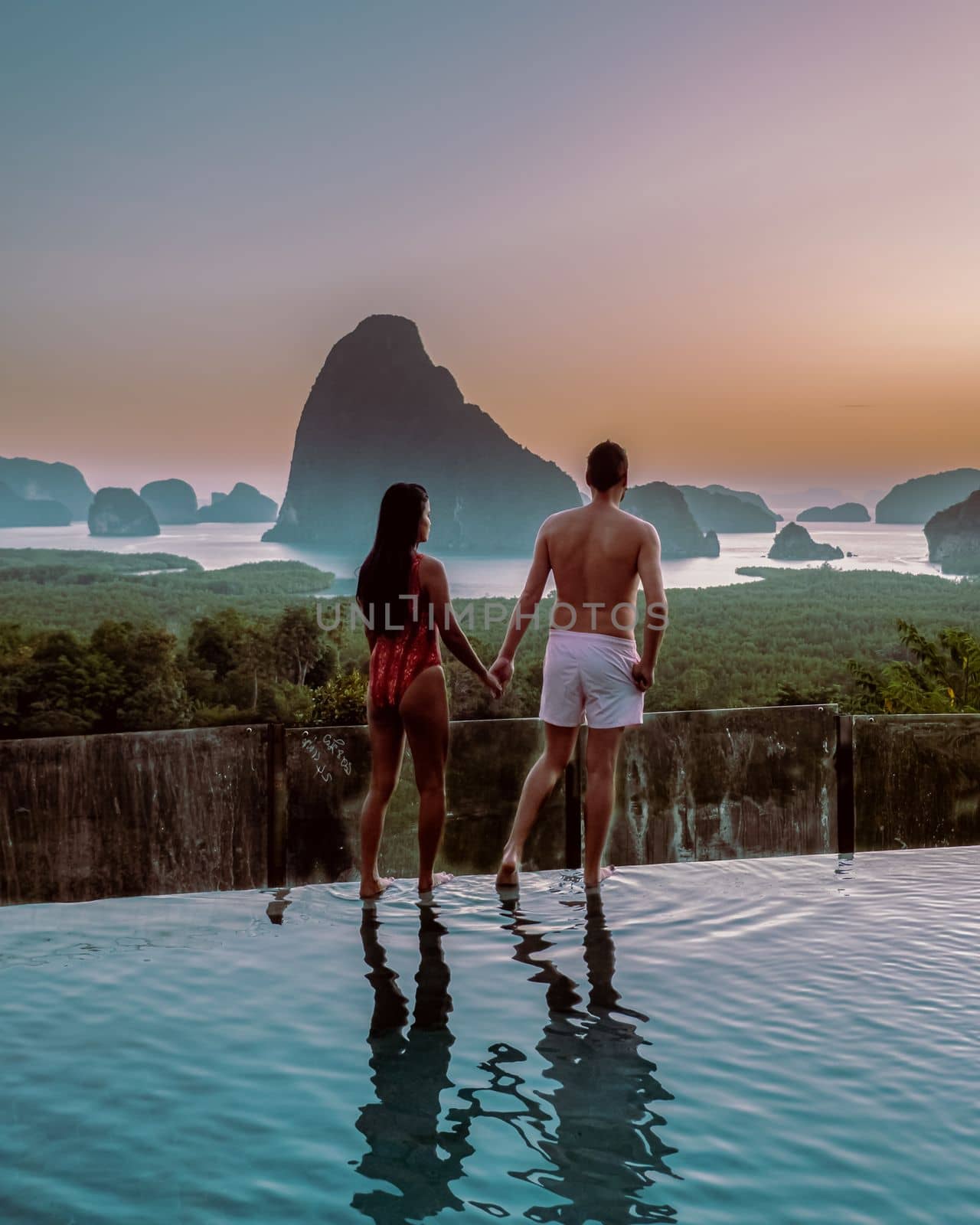 Phangnga Bay Thailand, couple on the edge of an swimming pool watching sunrise Thailand infinity pool honeymoon