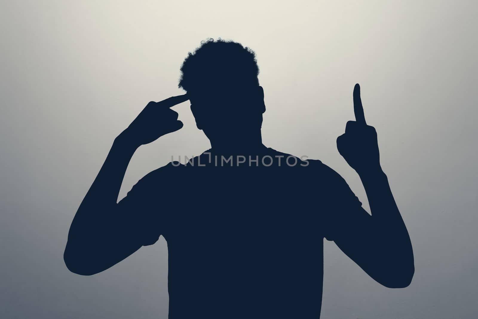 silhouette of man pointing upwards showing idea or eureka gesture generating interesting plan.