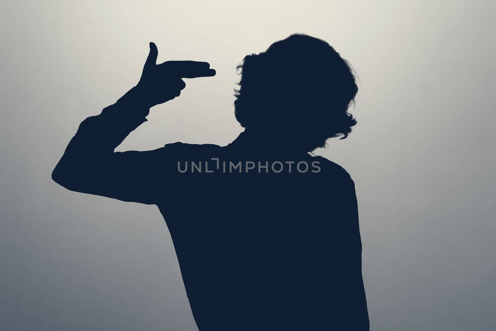 Silhouette of woman standing over isolated background pointing hand and fingers to head