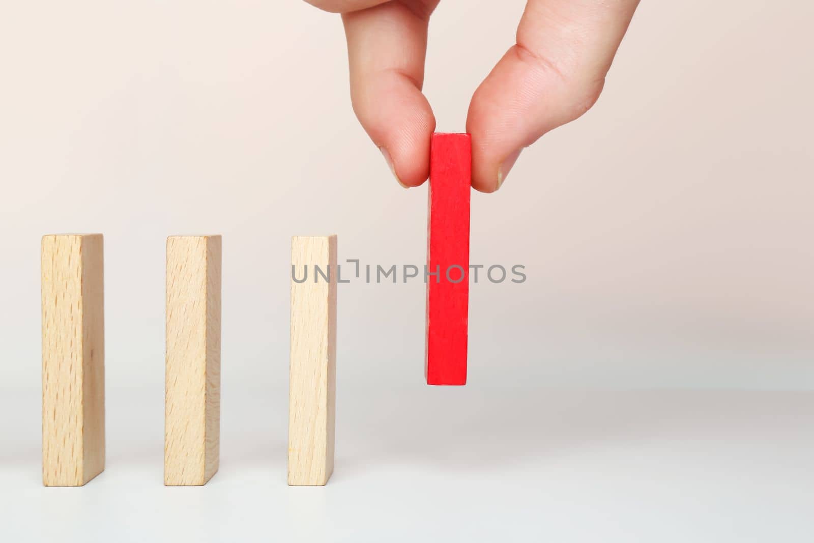A business concept with a domino effect. The hand puts dominoes to make a chain reaction