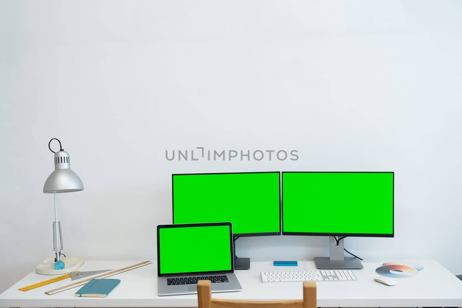 Green screen monitor stands on the office desk - Personal compute mock-up. High quality photo