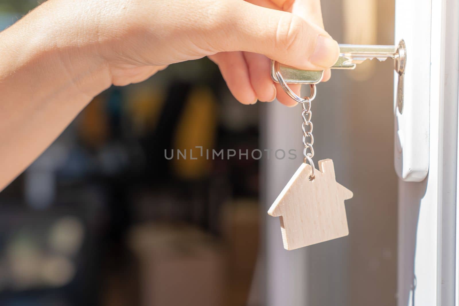 Opening door to a new home with key and home shaped keychain. Property and new home concept by PaulCarr