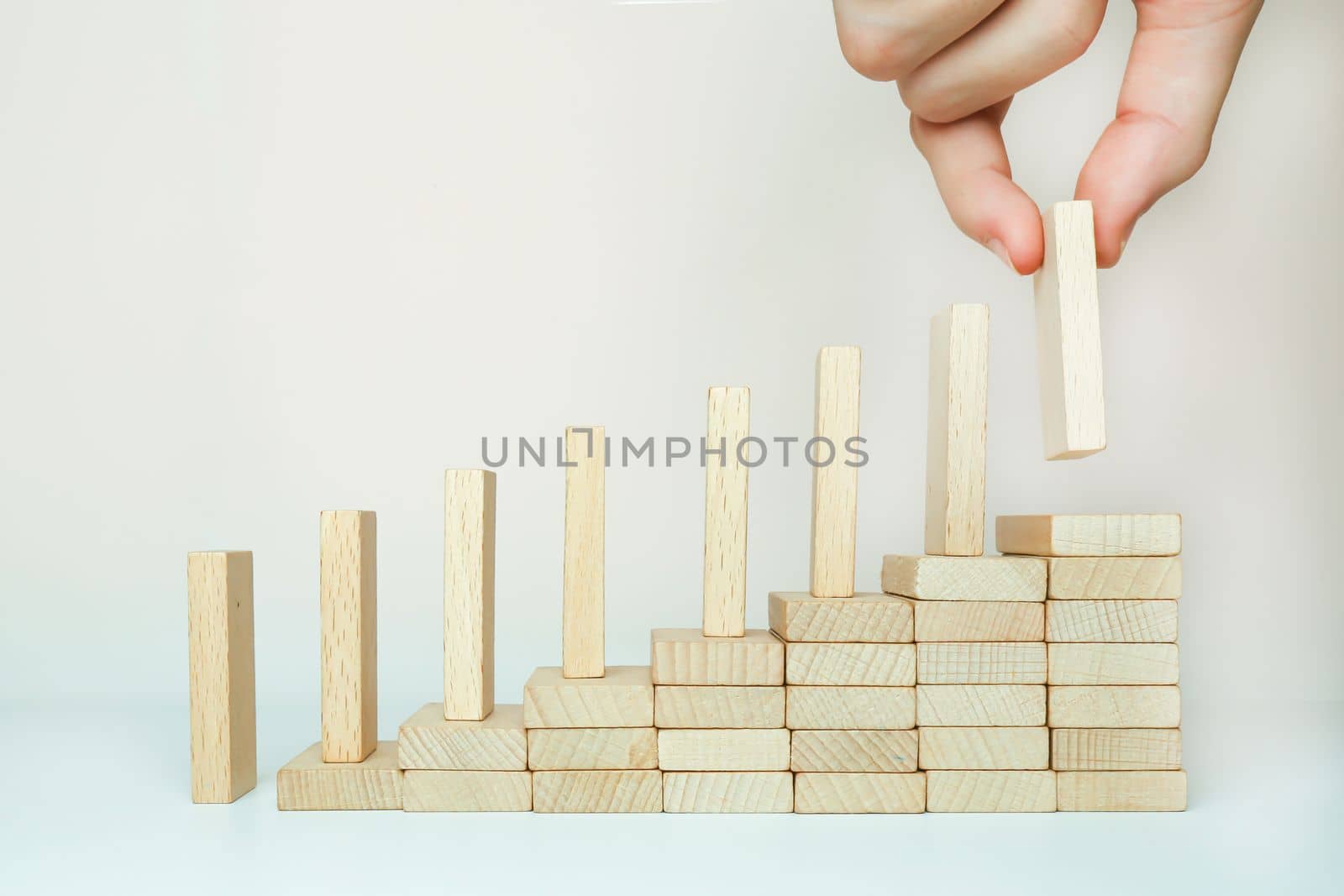 The domino effect is built by climbing the stairs on a wooden staircase lined with steps. One in hand