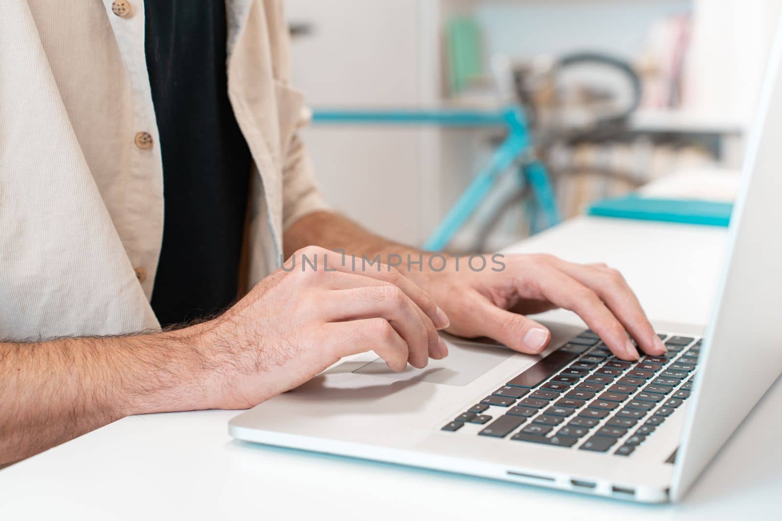 Unrecognizable man employee working on laptop at desk office, cropped image of young man typing on computer keyboard, writing email or communicating online. High quality photo