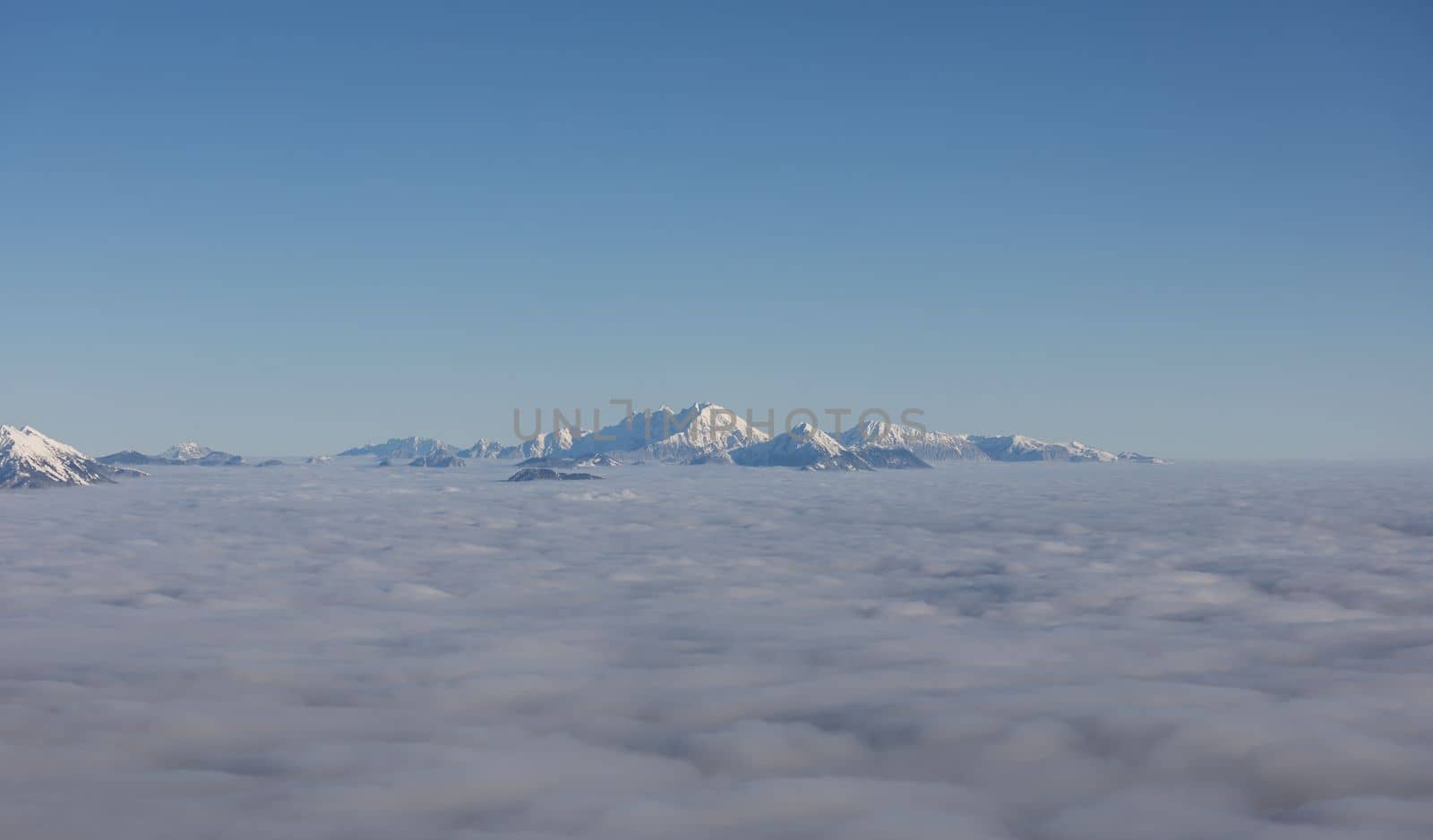 Winter mountains covered with snow landscape over clouds. High quality photo