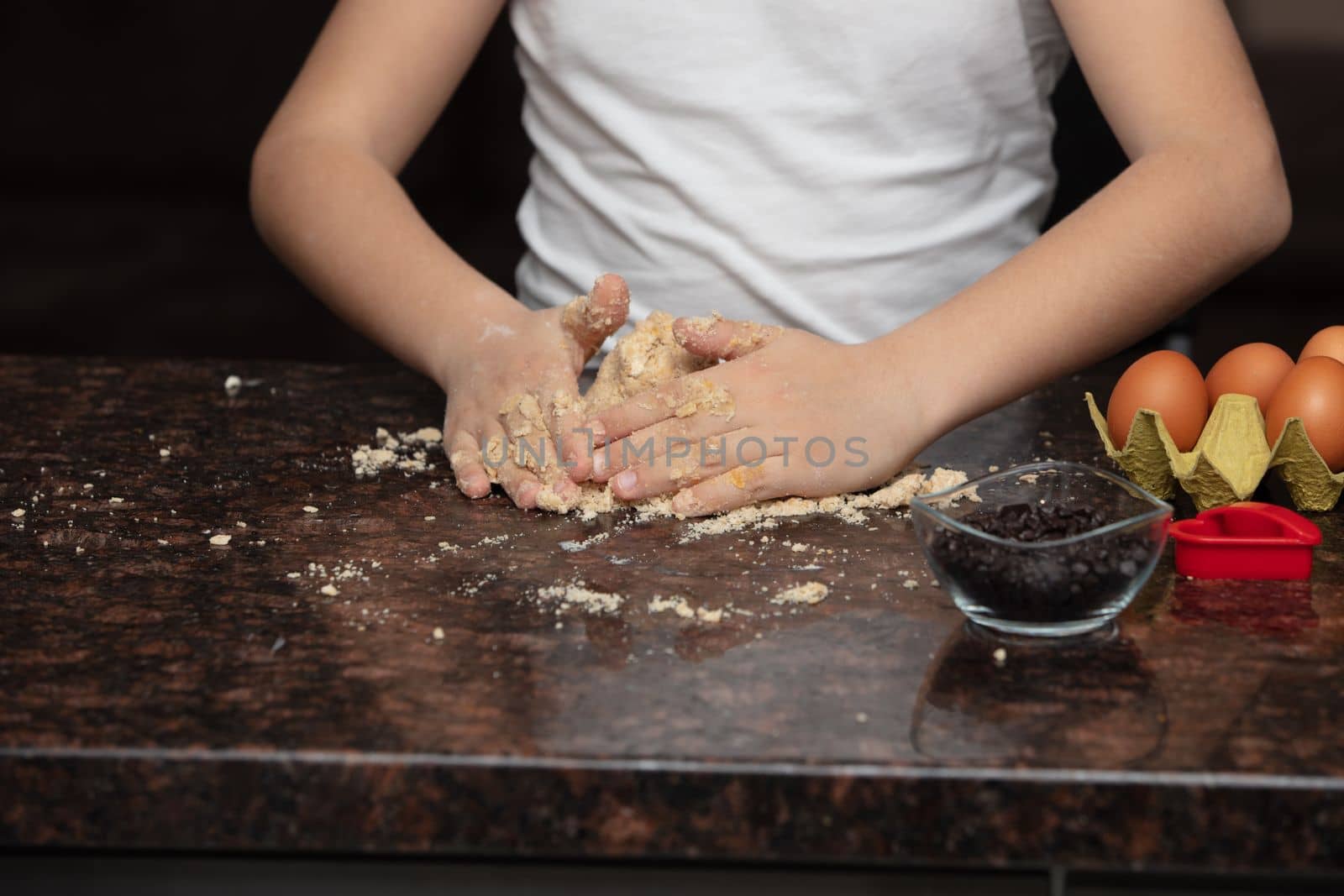 Kids baking cookies in house kitchen . Close-up child`s hands preparing cookies using cookie.
