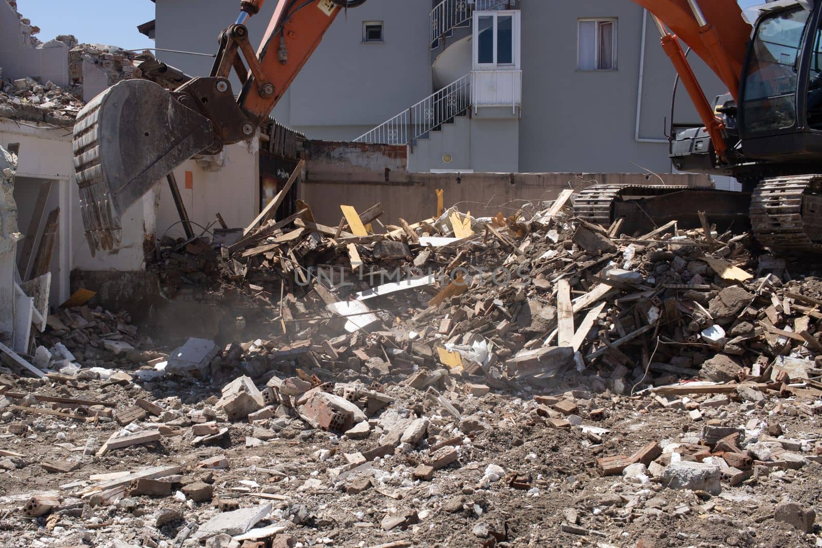 excavator loading debris of a destroyed building by senkaya