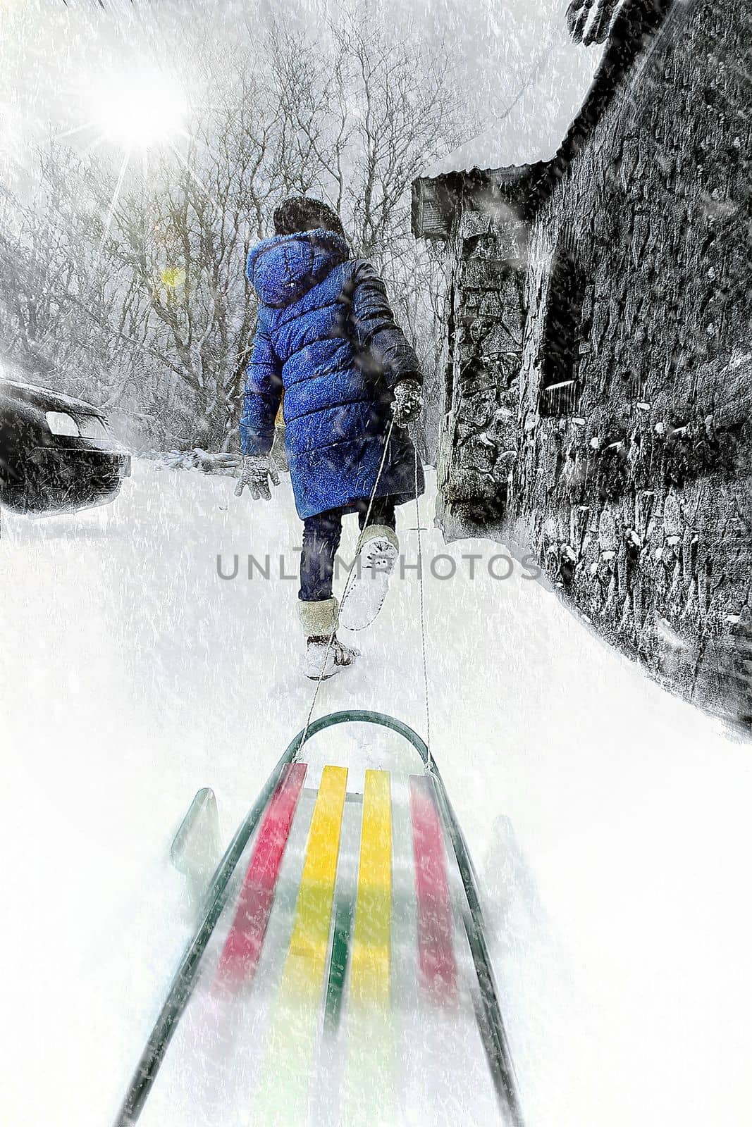 a child in the winter in the snow in a snowstorm pulls a sled walking creative photo. High quality photo