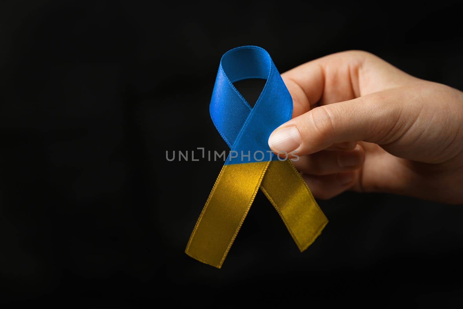 yellow blue ribbon in woman hands by alexxndr