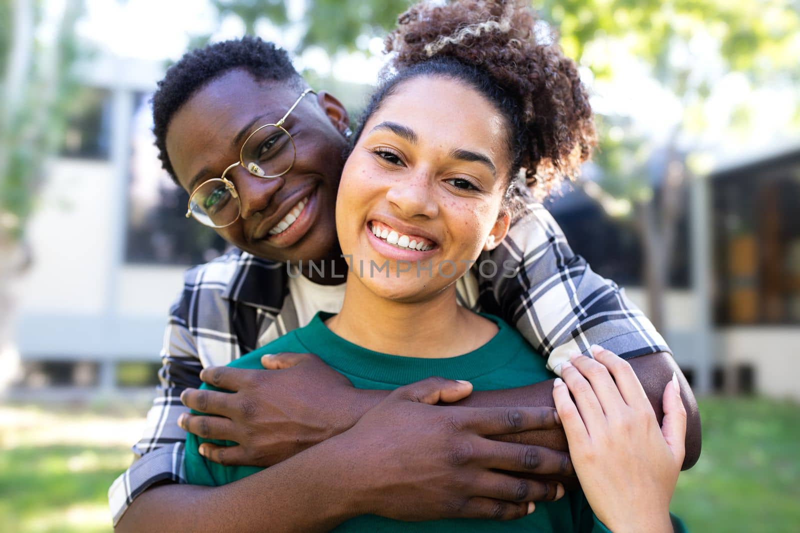 Young black loving couple embracing outdoors looking at camera. Loving relationship. by Hoverstock