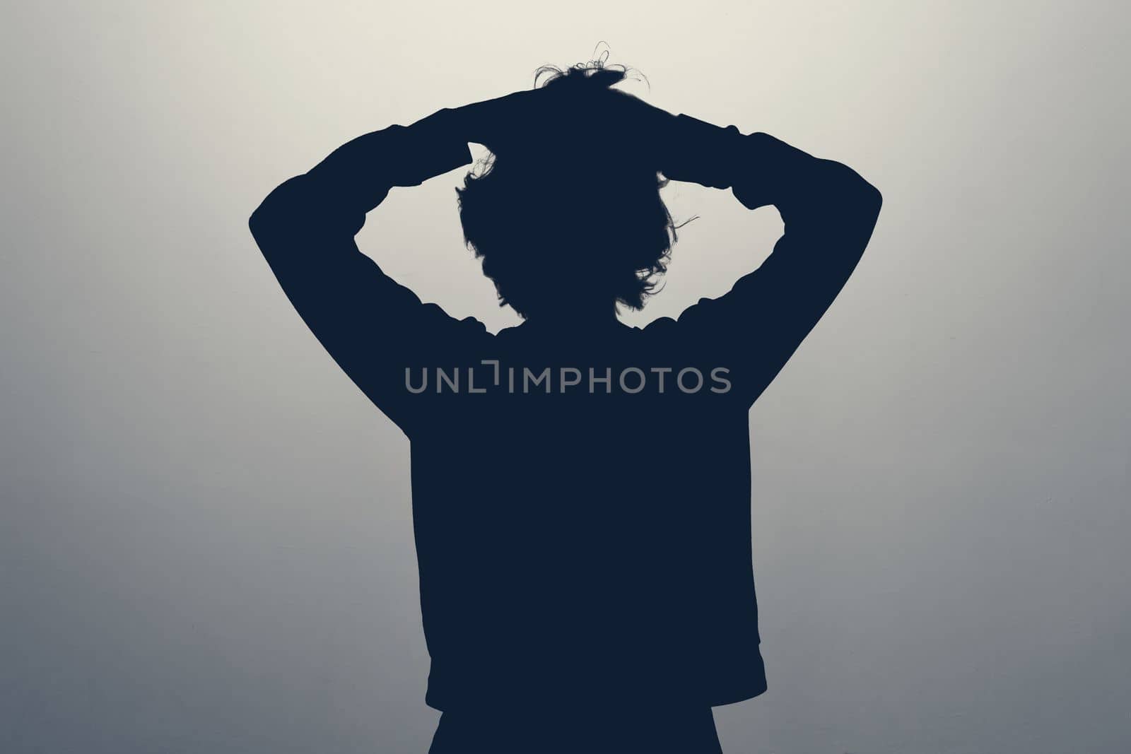 Anonym woman feeling frustrated holding her head in panic. silhouette photo