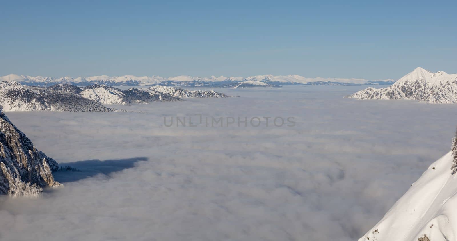 Winter mountains covered with snow landscape over clouds. High quality photo