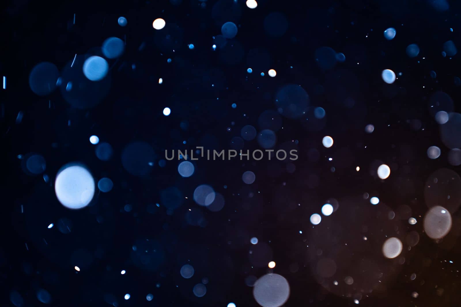 Closeup of dust particles on black background bokeh blur overlay effect with copy space for text. High quality photo