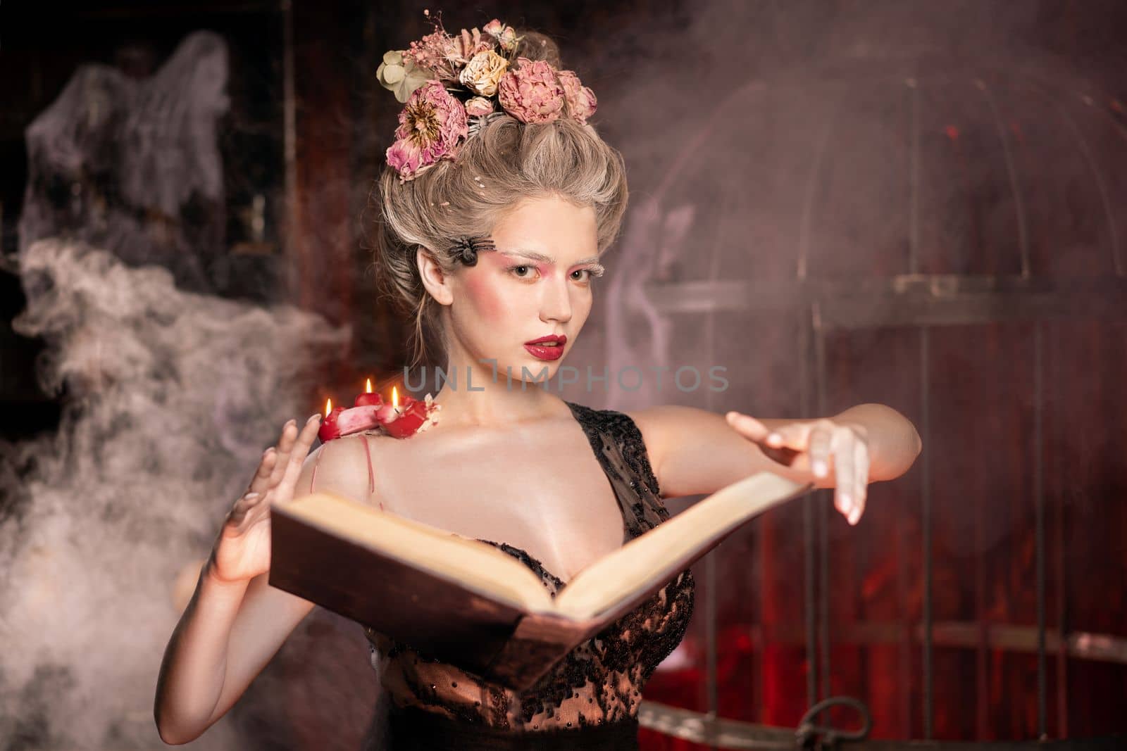 Charming woman witch flowers in hair vintage black dress with book of spell in the old castle Witchcraft concept, fairy tale mystic atmosphere. Conjure magic spells