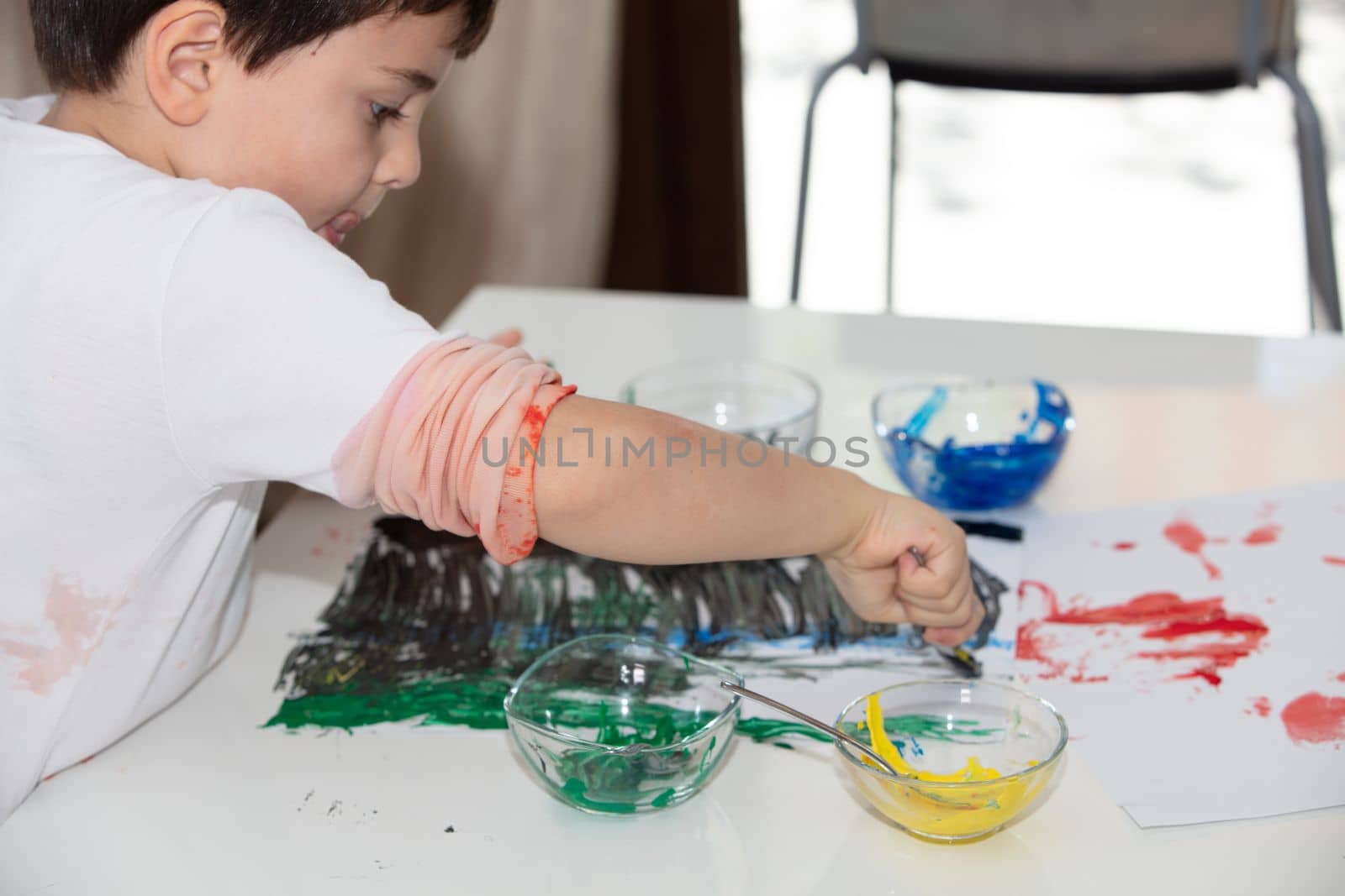 Child Finger Painting at home On Paper at covid time . stay at home