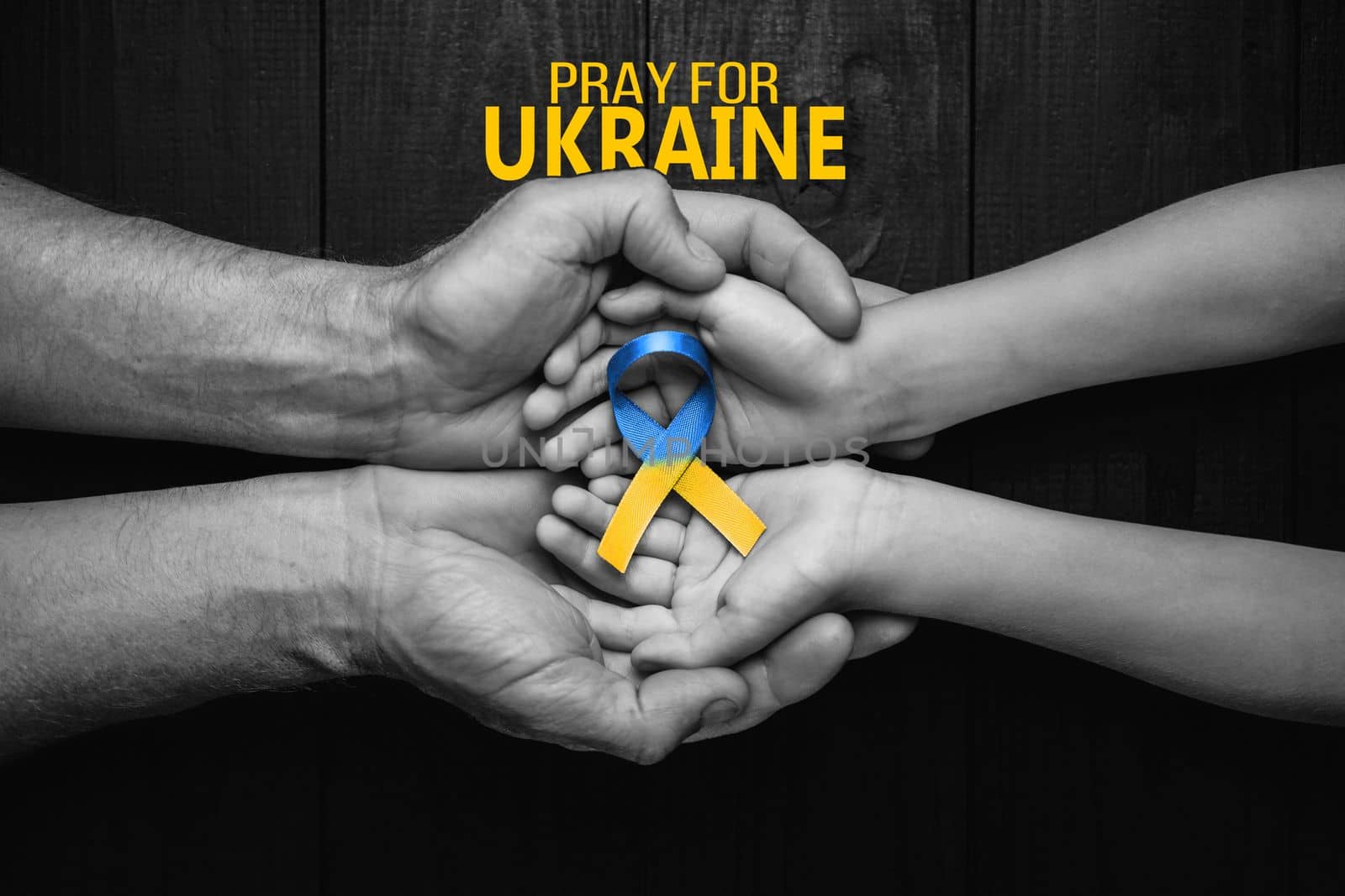 children hands in adult hands with ukraine ribbon by alexxndr