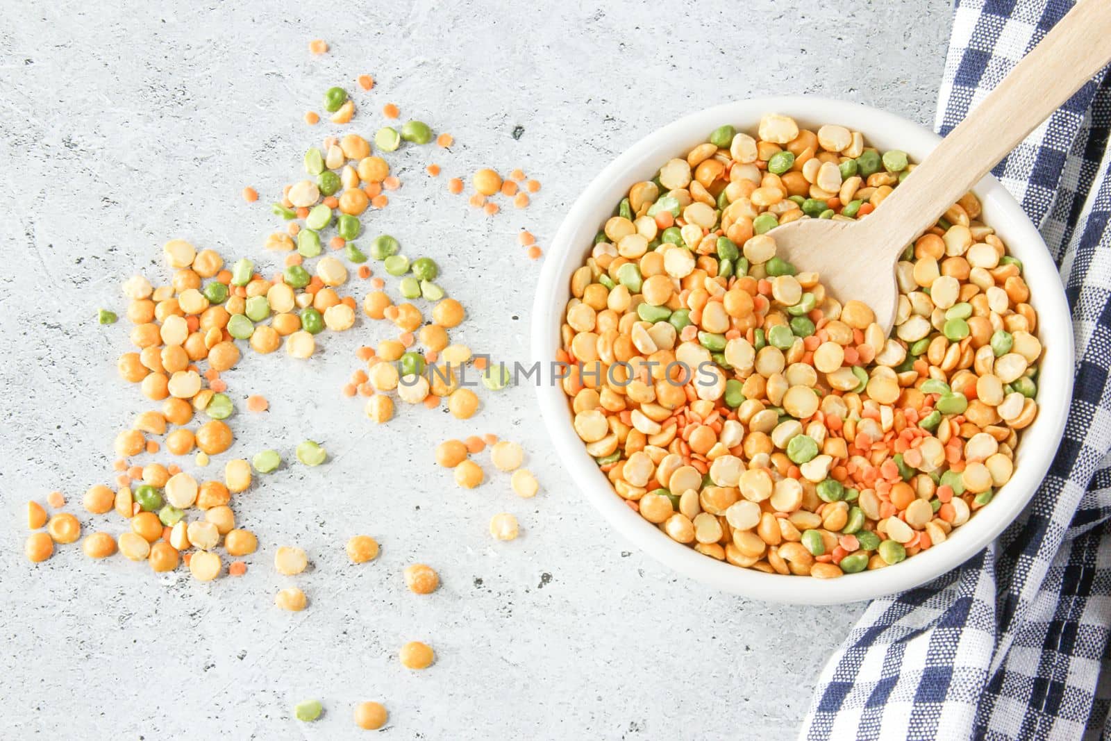 Different types of peas yellow and green in white bowl on gray stone background by IrinaKur