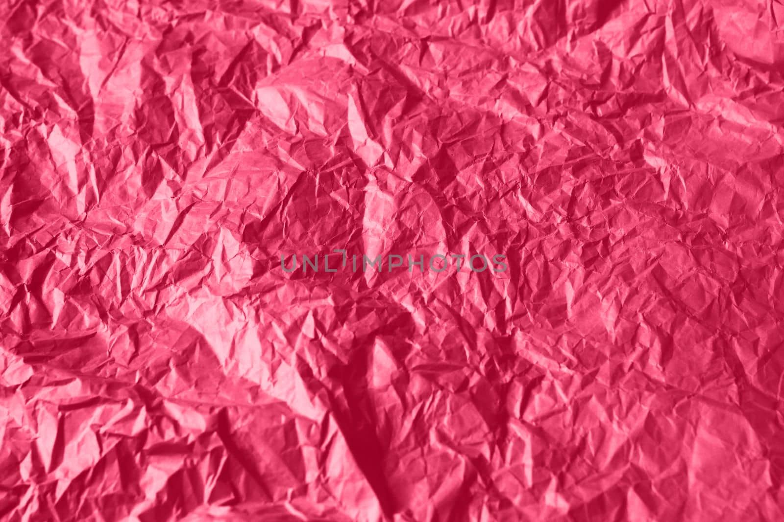 Crumpled paper Viva Magenta color of the year 2023. Texture crumpled paper for your design. Copy space. Viva Magenta color paper. High quality photo