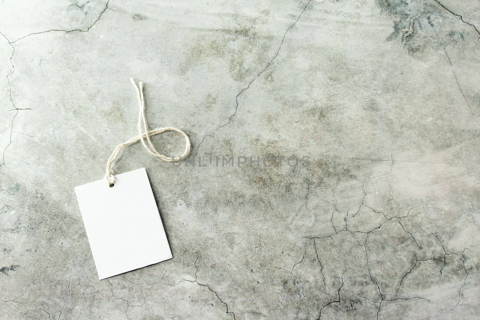 White gift tag mockup with white card, close up on gray background. Blank paper rectangular price tag mockup, Sale and Black Friday concept, element for design, label mockup