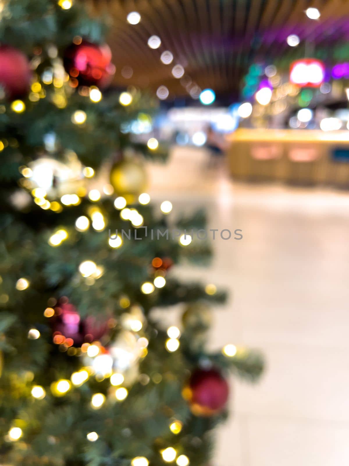 blurred decorated christmas tree in shopping mall background by Chechotkin