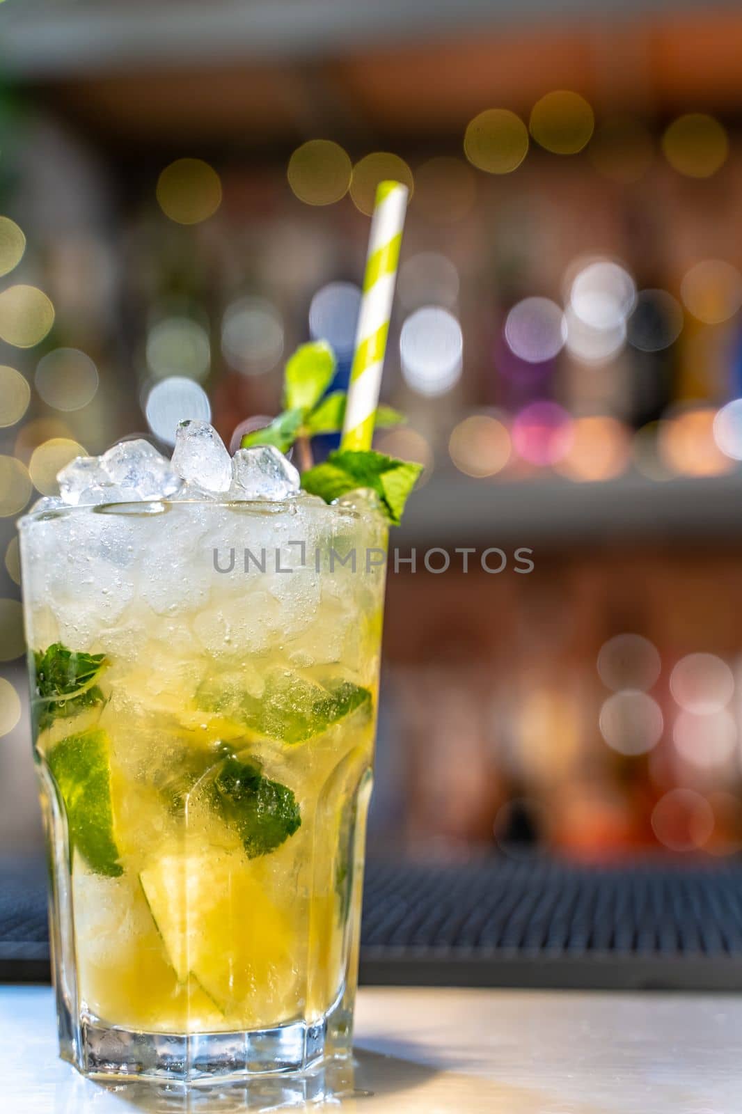 Mojito cocktail on bar counter with lemons, limes and species with copy space for text. High quality photo