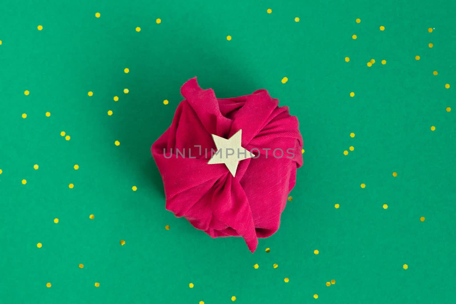 Paper free gift wrapping technique Furoshiki. Viva magenta fabric on green background. Flat lay, present box, top view. Christmas, valentines, new year concept. by Ri6ka