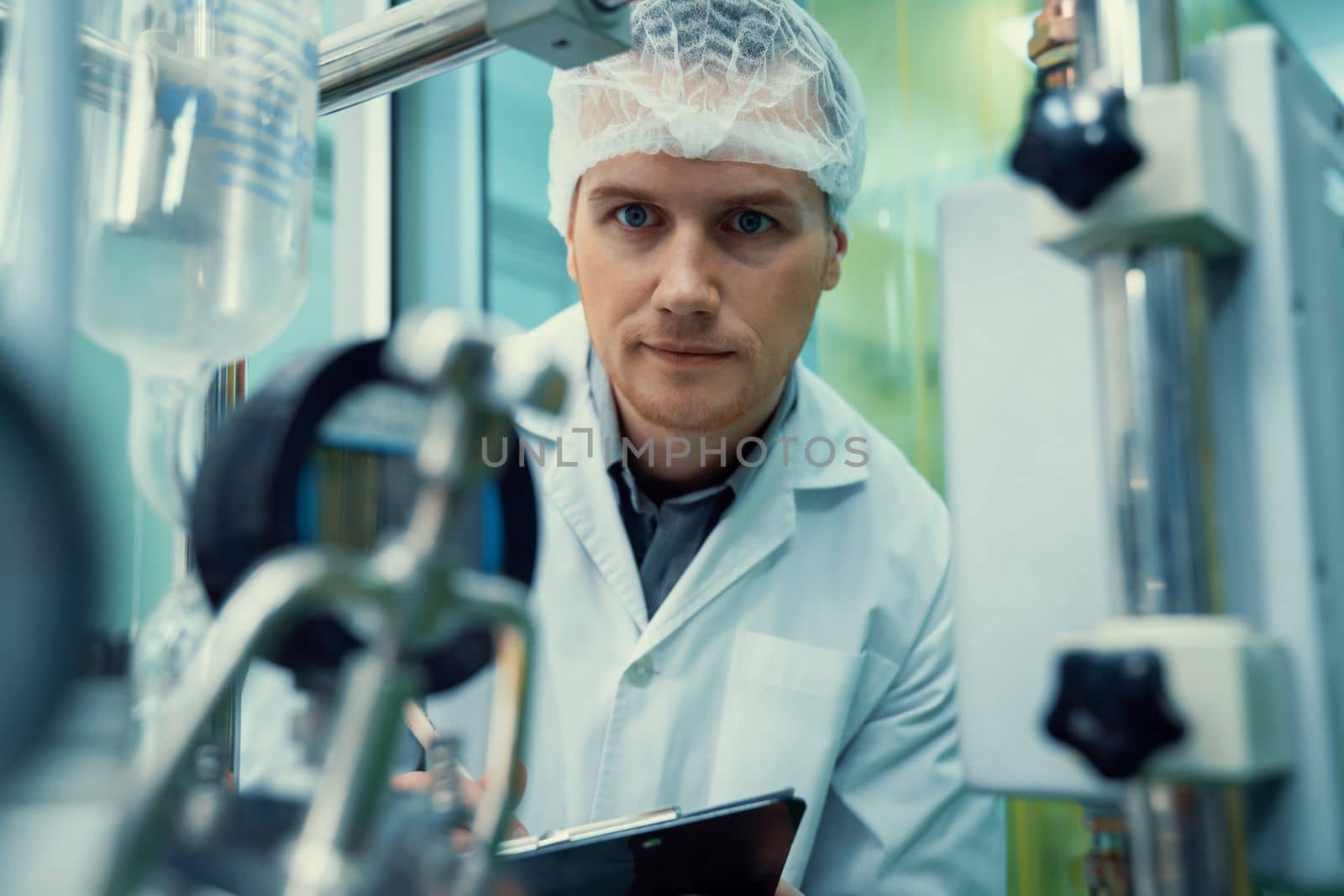 Portrait of a scientist, apothecary extracting cannabis oil in laboratory. by biancoblue