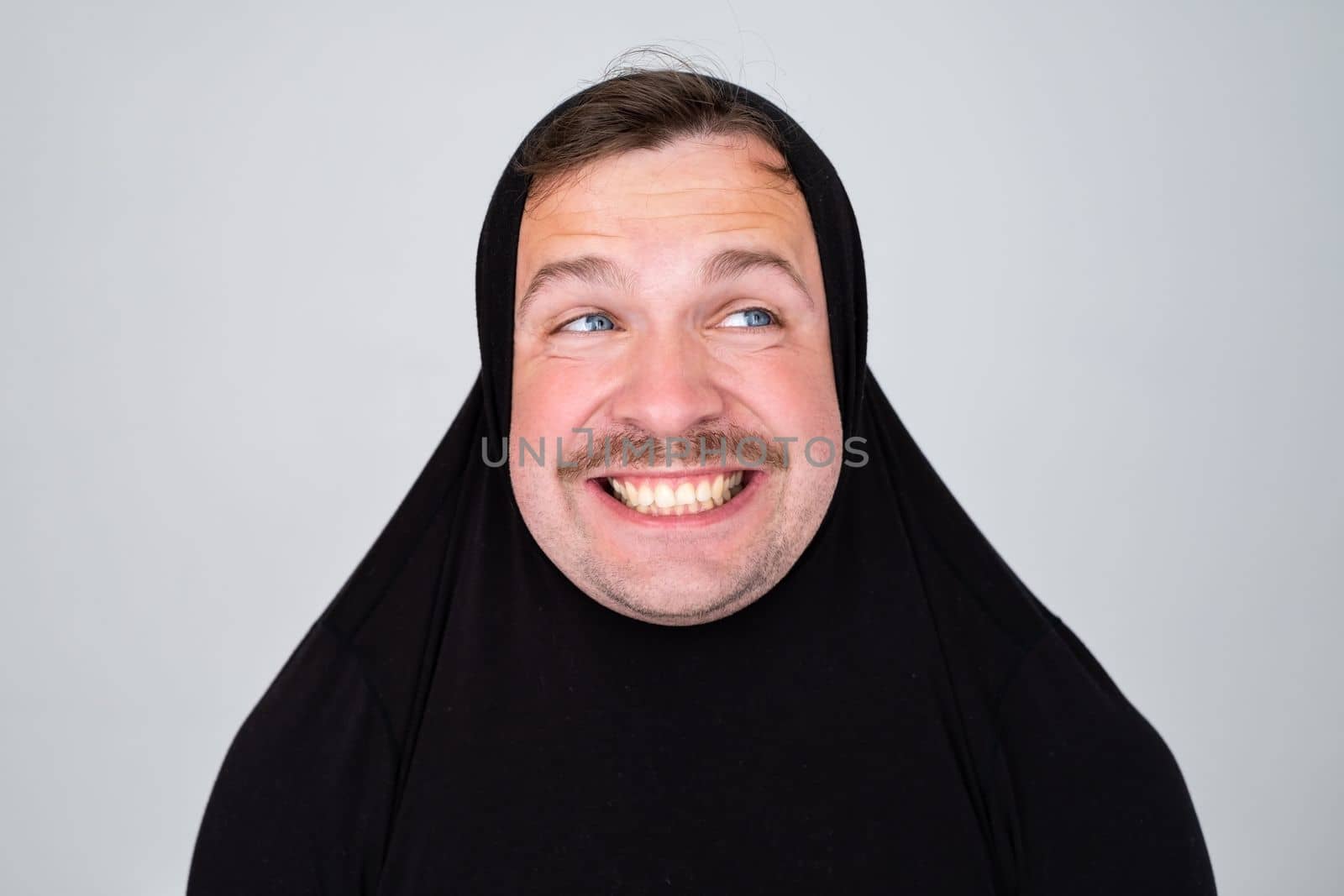 Funny caucasian man covering head with sweater smiling cheerful and funny. by koldunov