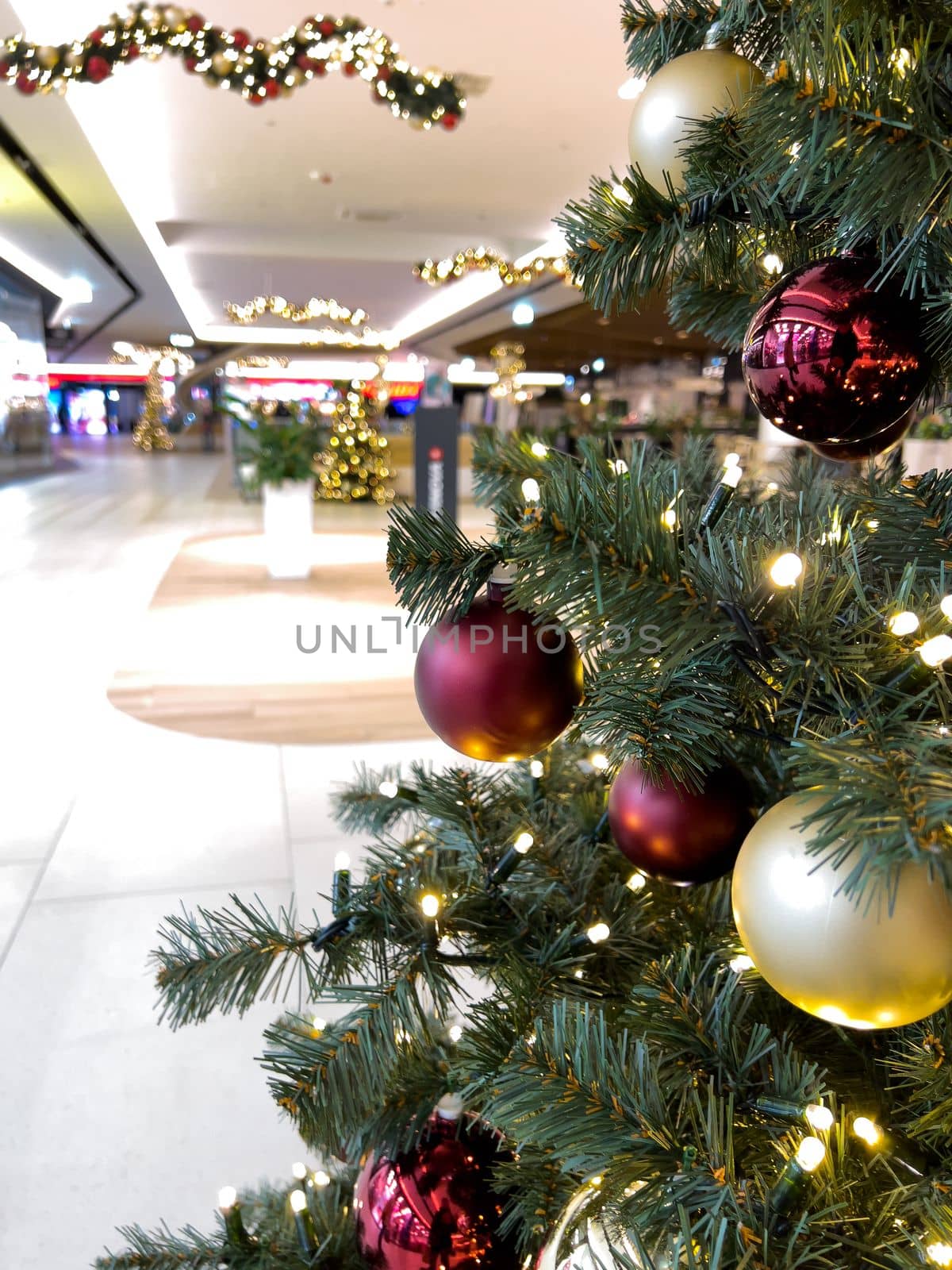 blurred decorated christmas tree in shopping mall background by Chechotkin