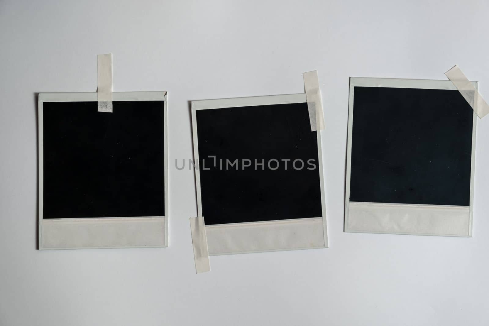 Collection of blank photo frames taped on white wall. Set of photos frame for your picture. Photo frame on a white background. download image