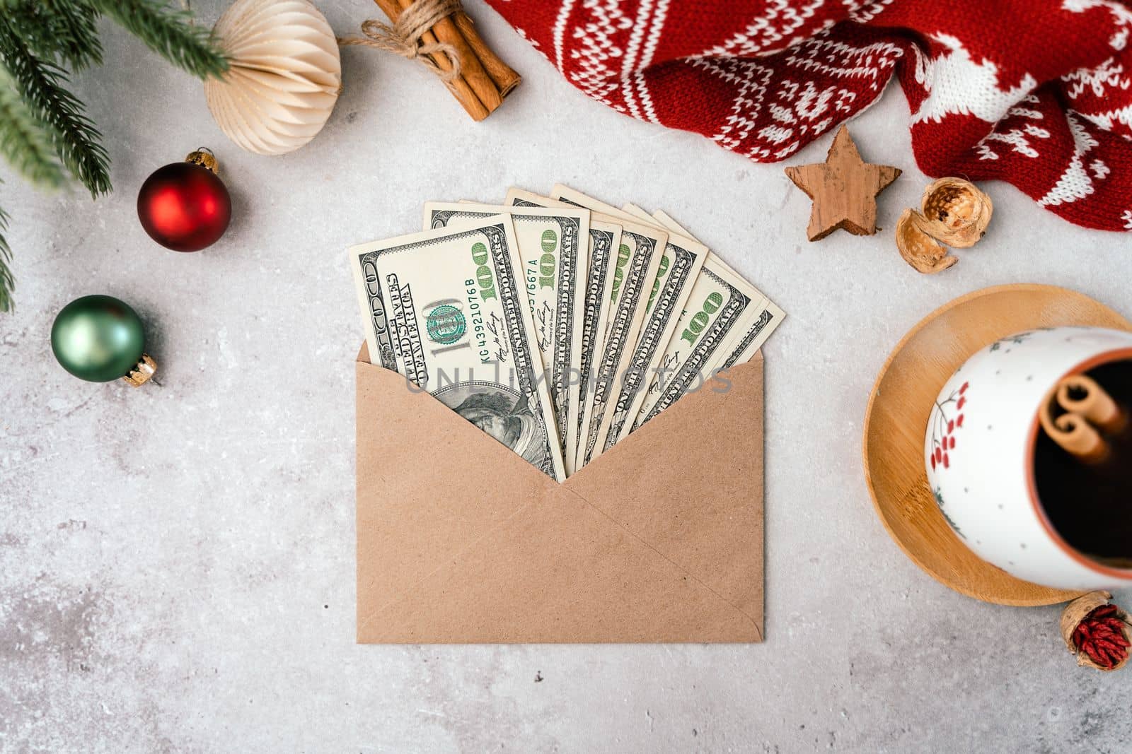 Paper envelope with money dollars bills for Christmas gifts. Top view counting budget for Christmas. Doing budget, estimate money balance for shopping spree. Flat lay with coffee and Christmas decor.