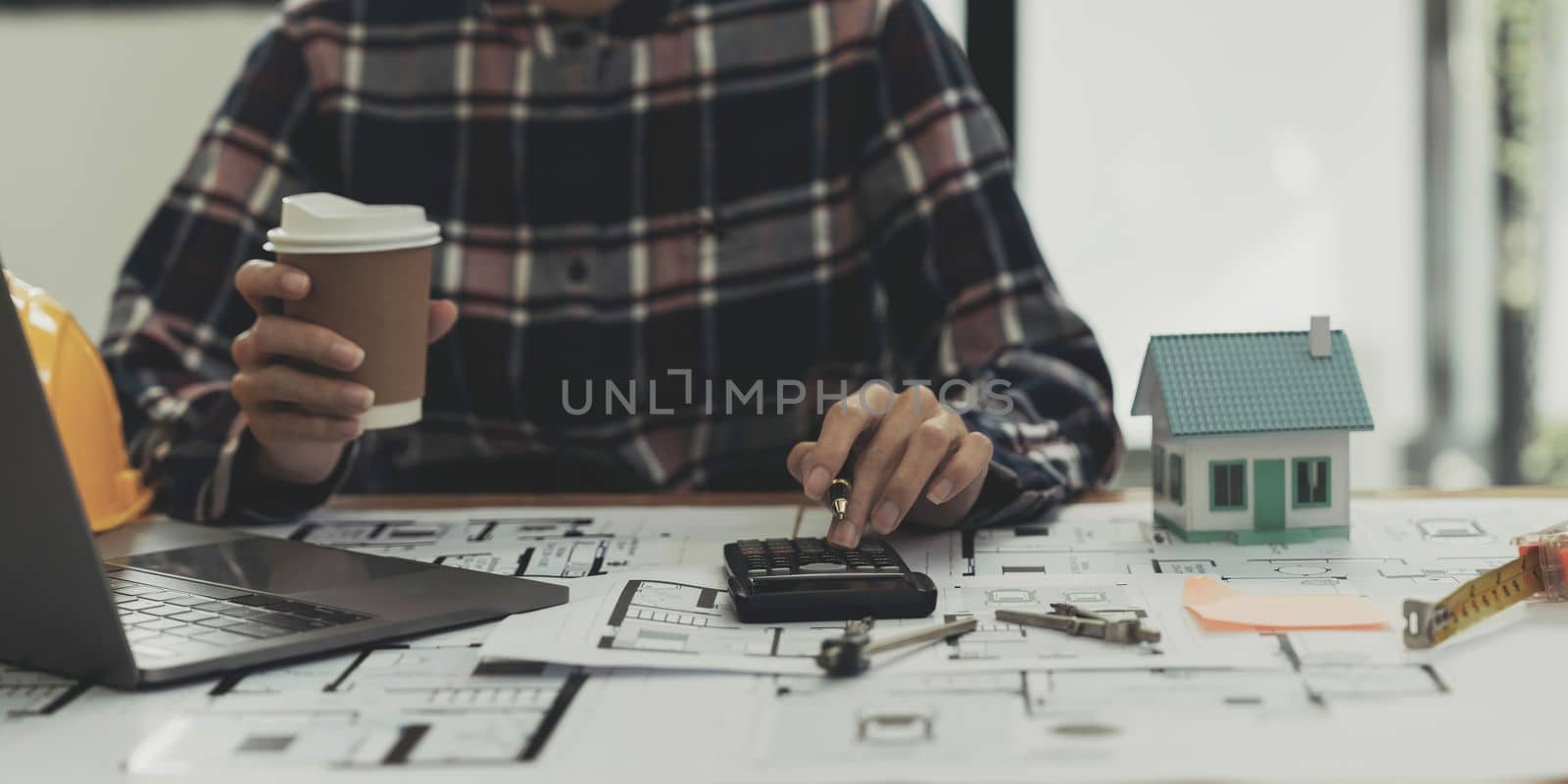 Concept architects, engineer holding pen pointing equipment architects On the desk with a blueprint in the office