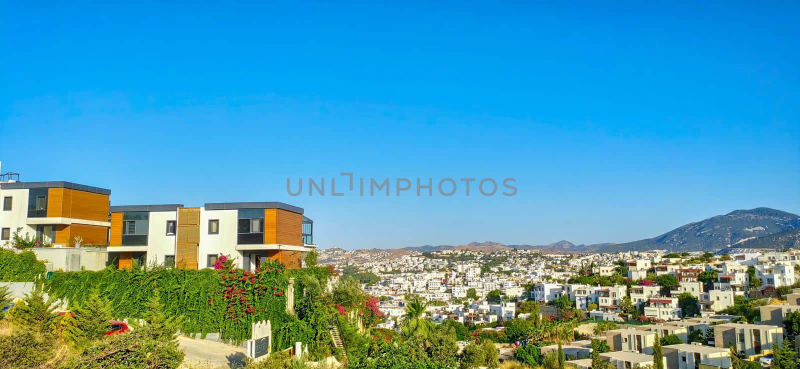 A tiny house on a green hill on the city background, vacation or just a peaceful relax. Modern architecture in the Scandinavian style. download image