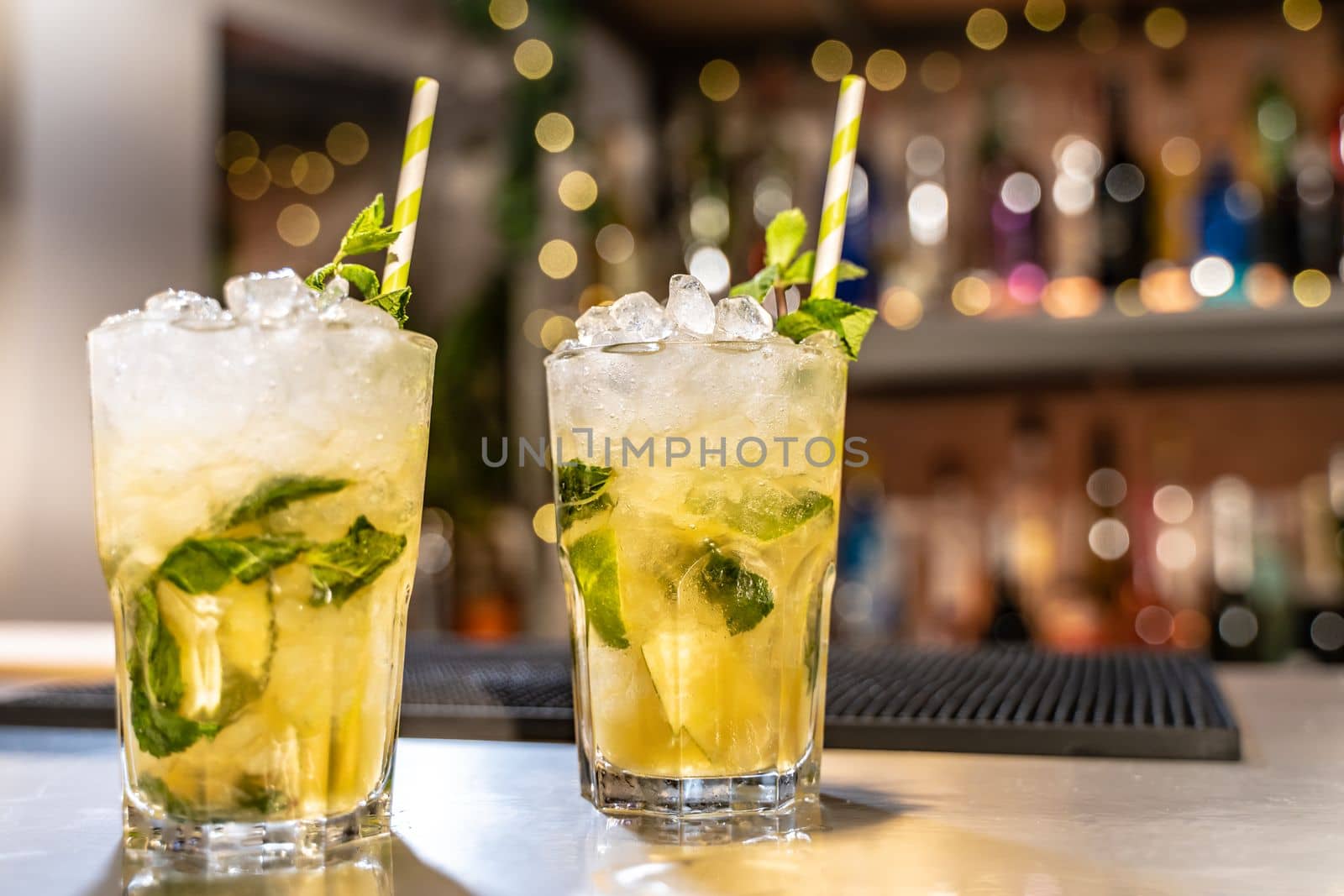 Mojito cocktail on bar counter with lemons, limes and species with copy space for text. High quality photo
