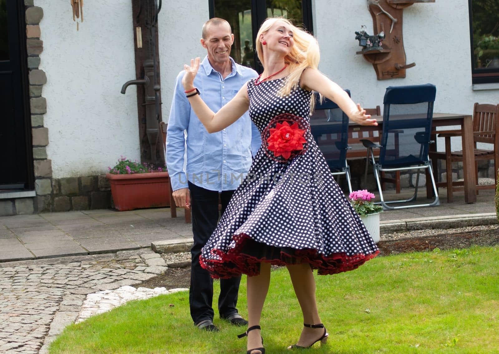 beautiful young couple of newlyweds dancing tango on the lawn in the garden. High quality photo