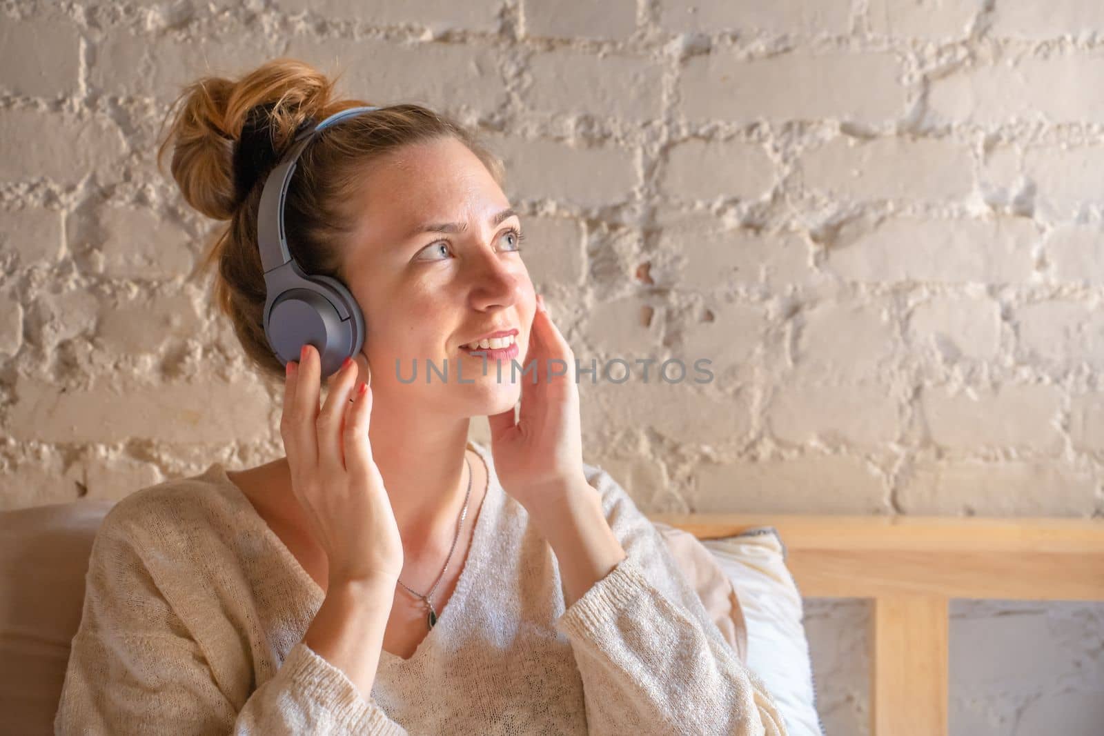 Portrait of a pretty young female listening music - Peaceful caucasian girl with modern wireless headphone - High quality photo