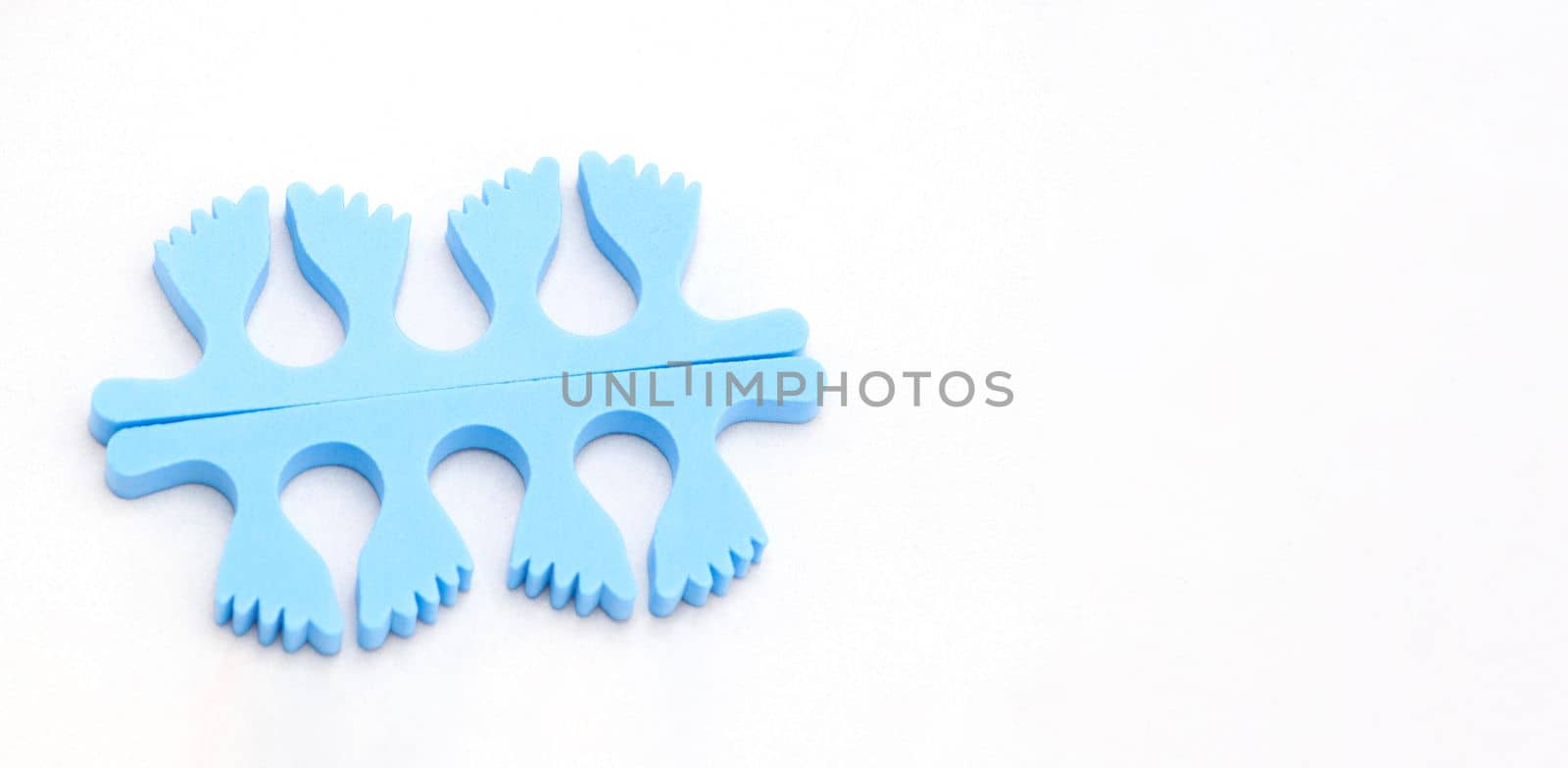 A pair of blue toe separators in the form of small feet, isolated on white background, Spongy material, copy space, High quality photo