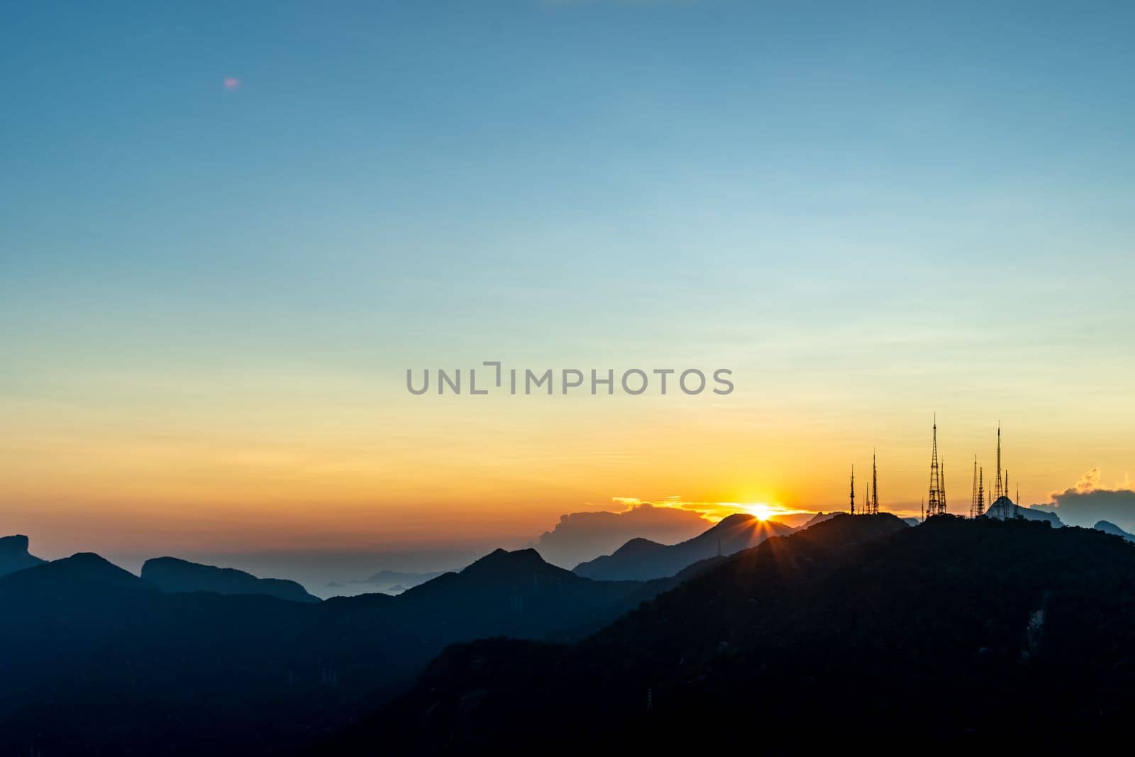 sunset over the transmission towers in rio de janeiro, view from the statue of christ.