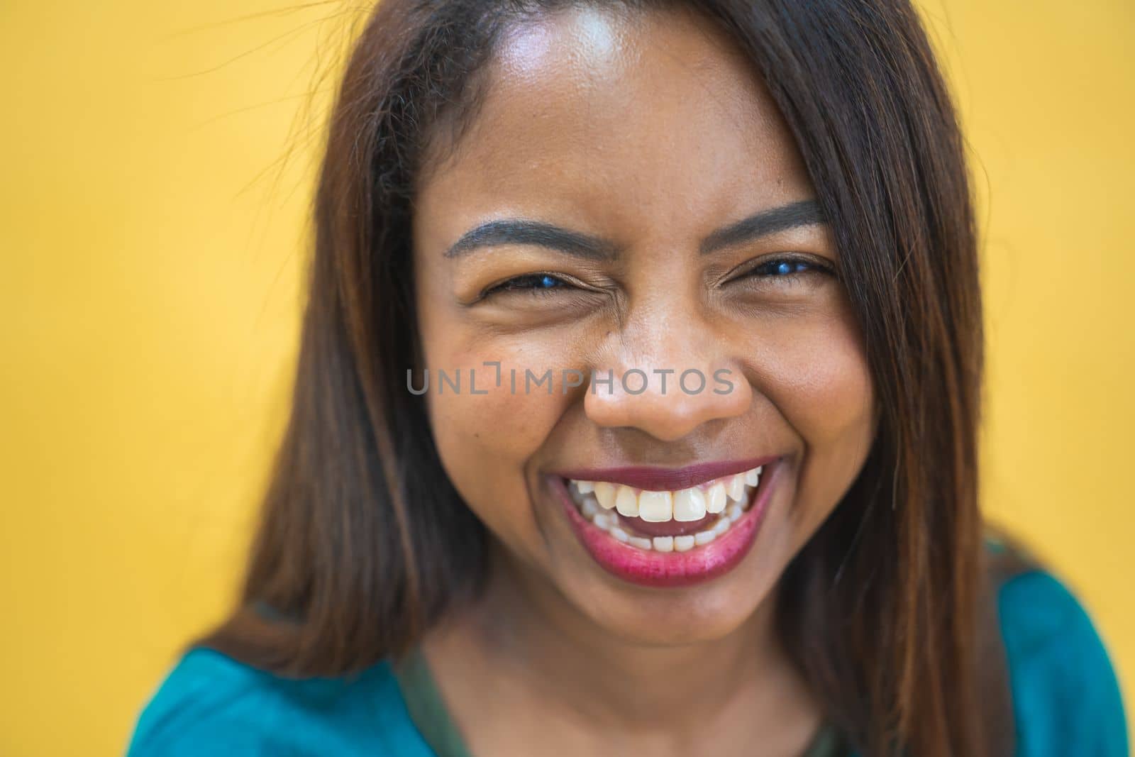 Portrait of beautiful brunette young dark-skinned woman smiling cheerfully - Yellow background. High quality photo