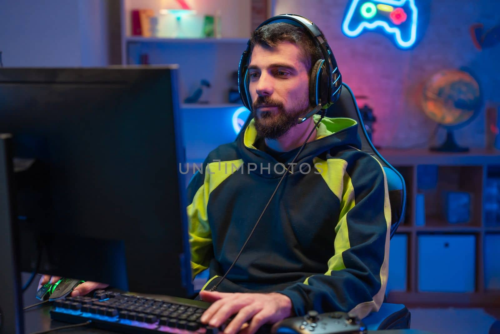 Male gamer focusing on online video games championship, playing action game on online live stream. Caucasian player having fun with virtual esport gameplay tournament on computer. High quality photo