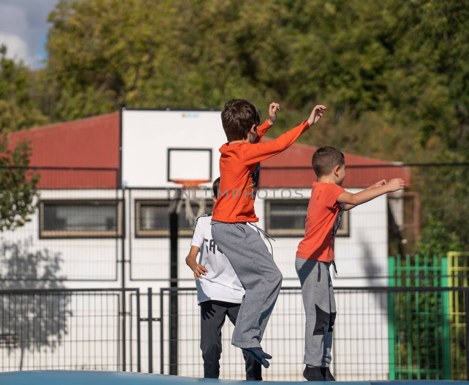 Children having fun in a playground. Two of them have same clothes and their movement is synced