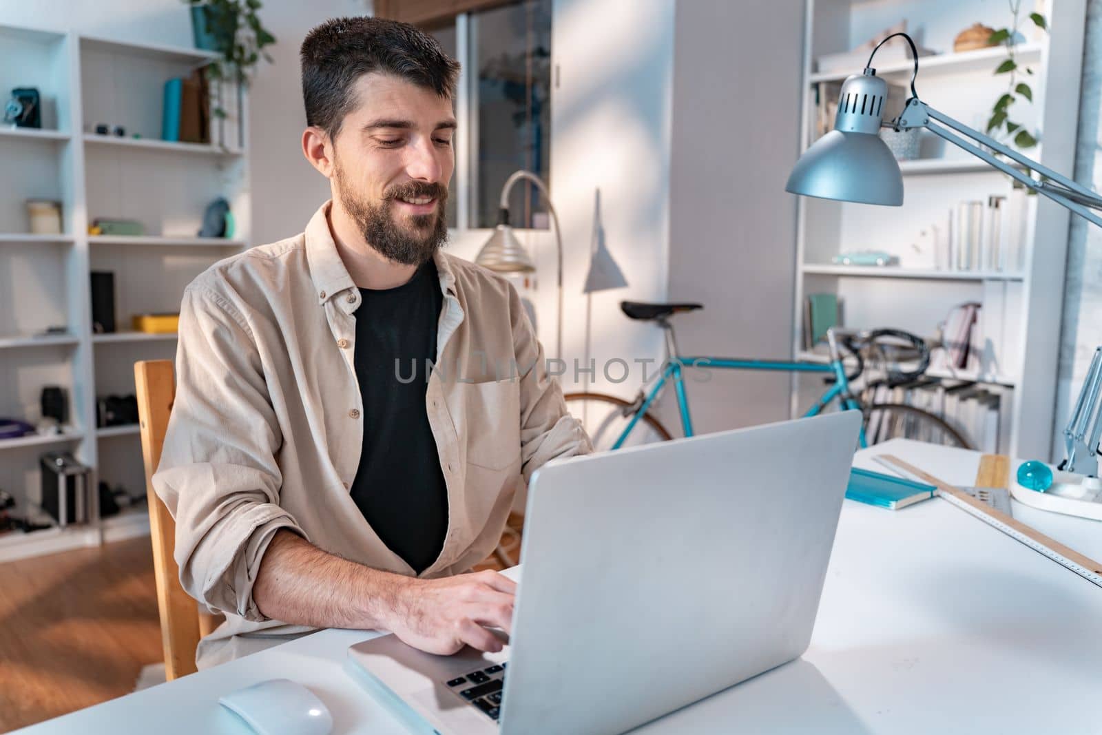 Happy young caucasian freelancer working on laptop at home - Entrepreneur man working remotely . High quality photo