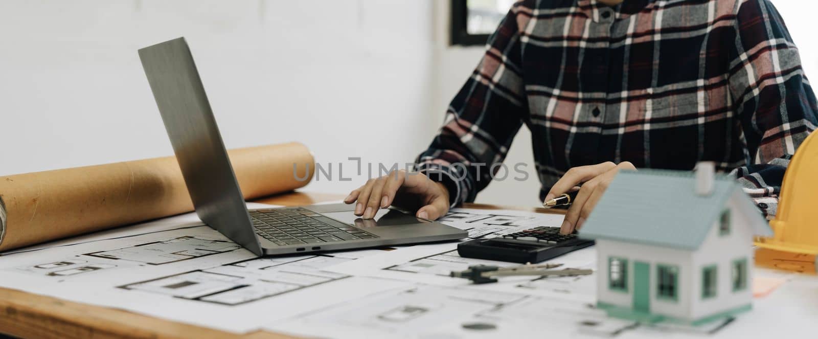 Concept architects, engineer holding pen pointing equipment architects On the desk with a blueprint in the office