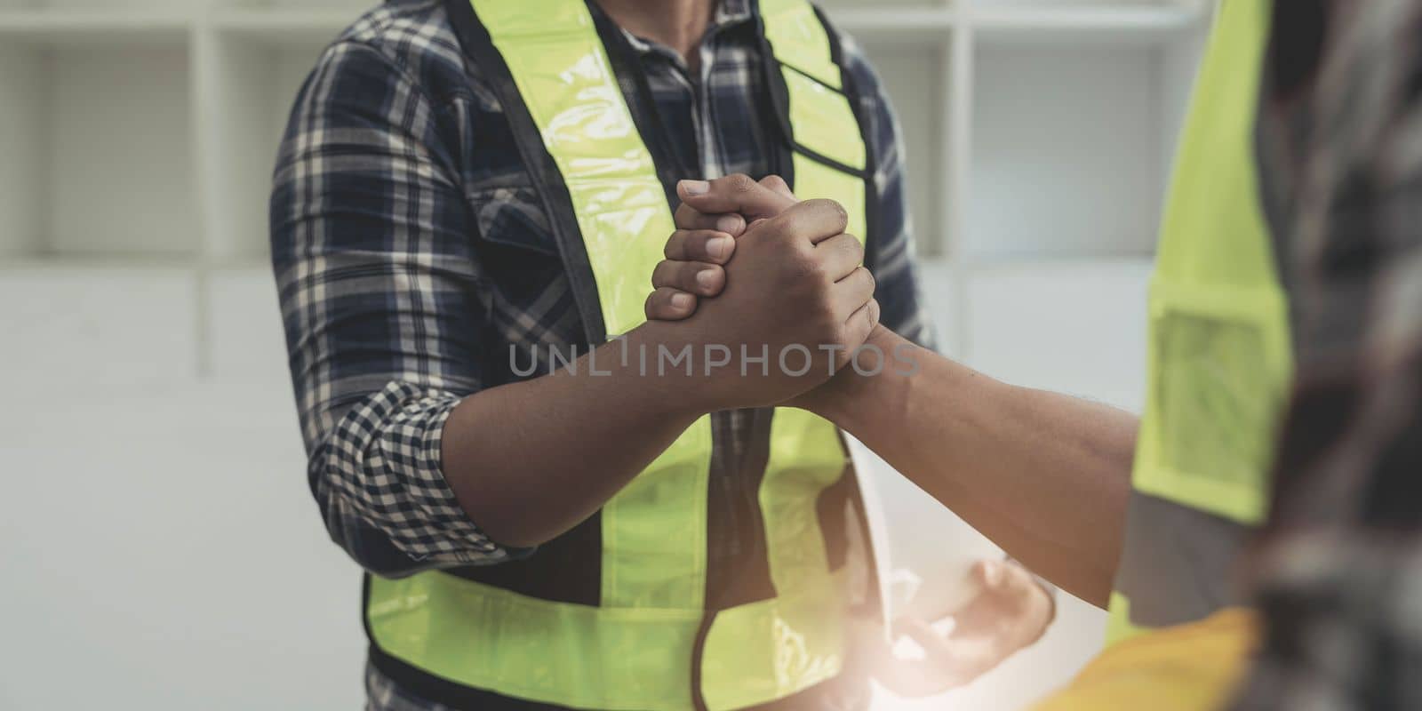 construction worker team hands shaking after consultation meeting to greeting start up plan new project contract in office center at construction site, teamwork, partnership and contractor concept..