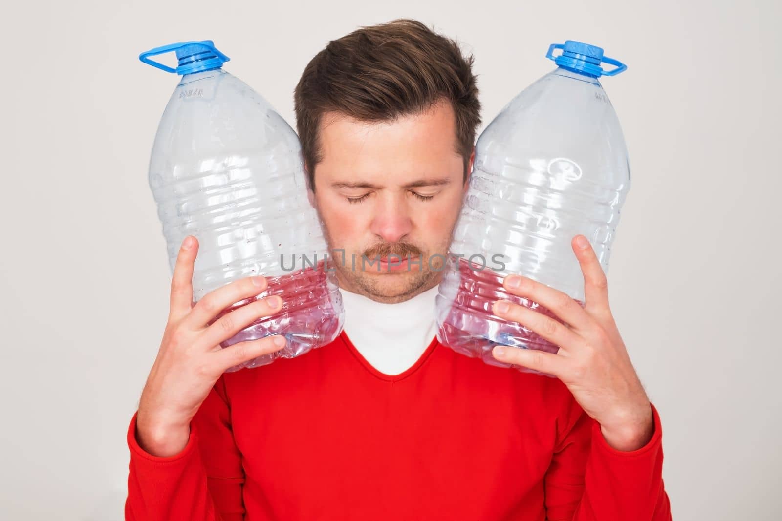 Caucasian man holding empty plastic bottles for water. Pure water crisis concept.