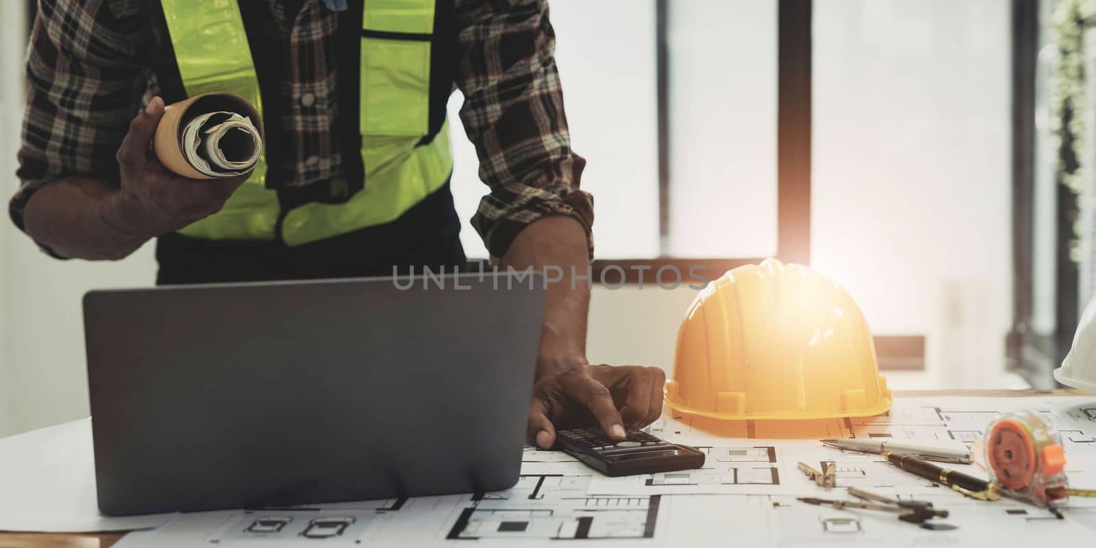 Close up of civil male engineer asian working on blueprint architectural project at construction site at desk in office