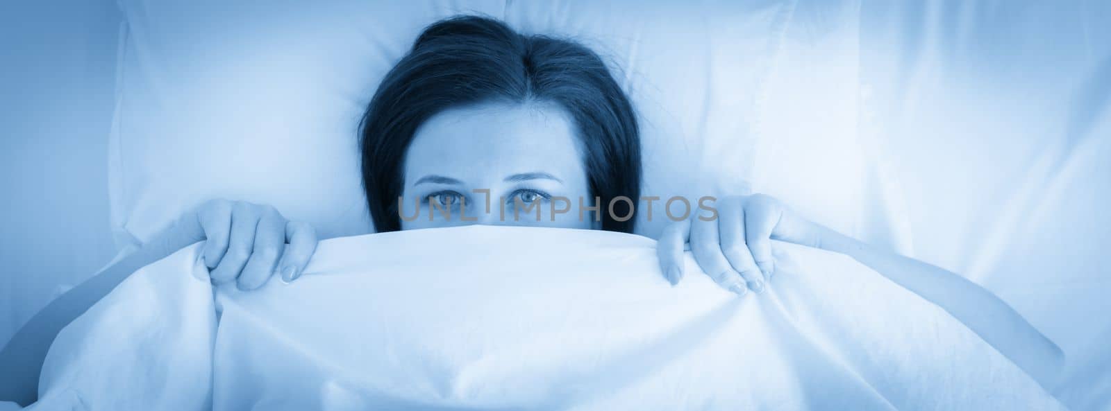 Panorama of young sad woman in bed, blue tone by Mariakray