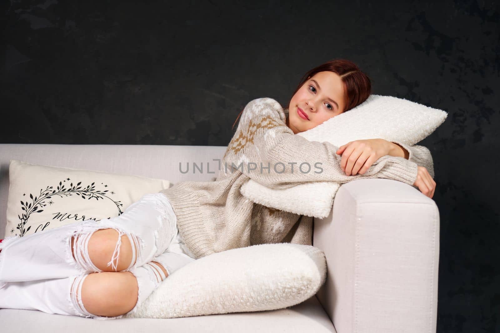 Gloomy teenager girl laying on sofa in ripped jeans. teenage having rest after school day. Positive redhead teenage girl lying on a couch.