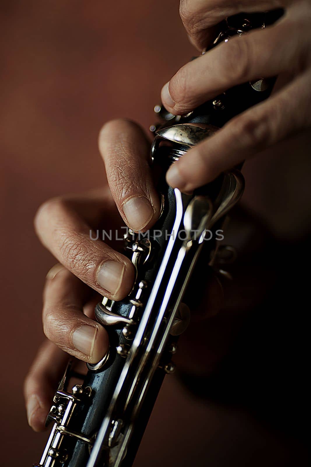 the hands of a musician on the clarinet - an ancient musical wooden instrument popular in classical brass marching jazz folk music, loved by children and adults, amateurs and professionals.. High quality photo