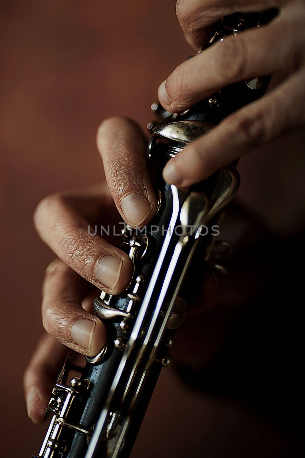 the hands of a musician on the clarinet - an ancient musical wooden instrument popular in classical brass marching jazz folk music, loved by children and adults, amateurs and professionals. by Costin